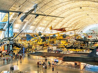 The Boeing Aviation Hangar at the Steven F. Udvar-Hazy Center is a vast open space filled with airplanes on both the floor and hanging from the ceiling, tilted at angles that convey the impression of flight.