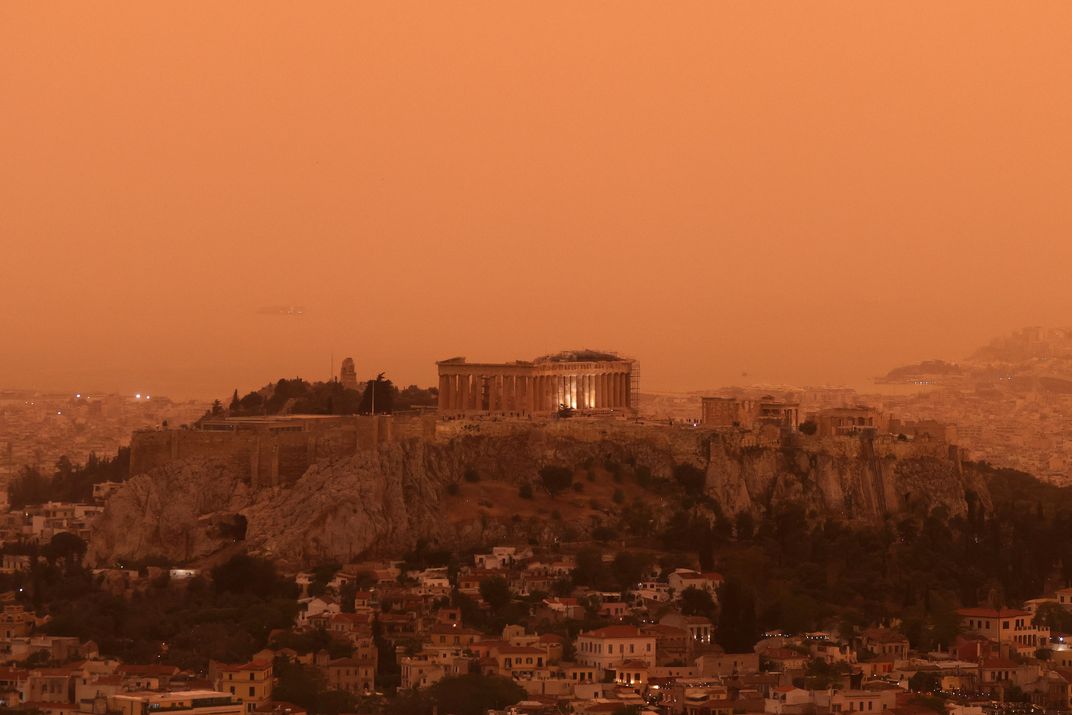 A wide-angled view of the city of Athens, turned orange from dust blown from the Sahara desert.